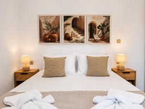 a bedroom with a large white bed with two lamps at Villa Apelati in Keri