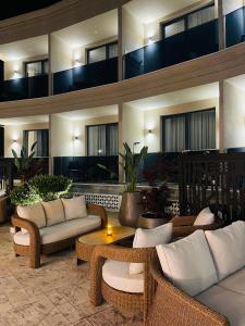 a lobby with wicker chairs and tables in a building at EBBI HOTEL in Dhërmi