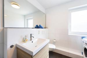 a white bathroom with a sink and a toilet at Appartementanlage Wieben in Böhl +28 photos
