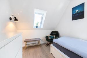 a bedroom with a bed and a chair and a window at Appartementanlage Wieben in Böhl