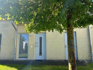 a house with a blue door and a tree at Lontargos OG Wohnung in Göhren-Lebbin