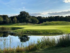 a golf course with a pond next to a green at Villa Sole am Fleesensee in Göhren-Lebbin