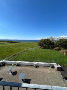 a patio with a table and benches and a field at Fanore Apartment 1 in Fanore