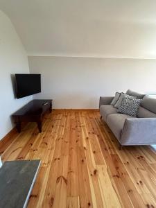 a living room with a couch and a flat screen tv at Fanore Apartment 1 in Fanore