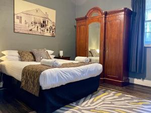 a bedroom with a large bed with a wooden cabinet at Whites Corner in Bothwell