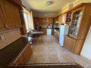a kitchen with wooden cabinets and white appliances at Willa u Bociana in Siemianówka