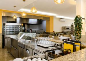 a large kitchen with stainless steel counter tops and sinks at AC Hotel in Luanda