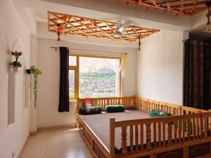 a bed in a room with a large window at The Apricot Palace in Kargil