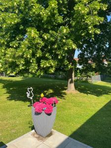 a vase filled with pink flowers in a park at FeWo Atlanta in Reinhardshausen