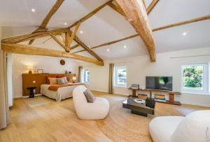 a bedroom with a bed and a couch and a tv at Chambre d'hôtes "Ô berges de Brens" in Brens