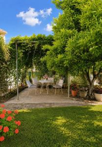 a patio with a table and chairs in a garden at Acheron House in Gliki