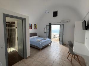 a bedroom with a bed and a view of the ocean at Tarelis Beach Apartments & Studios in Kamari +171 photos