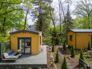 a small yellow house with a wooden deck at Hygge Tiny House 1 - Berlin Brandenburg in Berlin