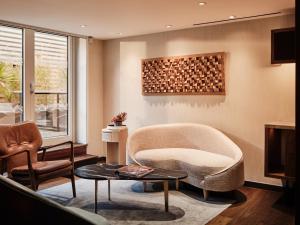 ein Wohnzimmer mit einem Stuhl und einem Tisch in der Unterkunft Middle Eight - Covent Garden in London