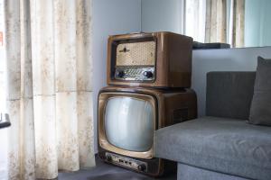 an old tv sitting on top of a couch at Collector's Home in Braga