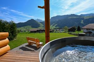 a hot tub on a deck with a bench at Mein Refugium Relax Tiny Haus in Unteriberg