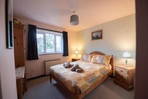 a bedroom with a bed and a window at Green Beck Cottage, within walking distance of the lake, shops, pubs & restaurants of Coniston in Coniston