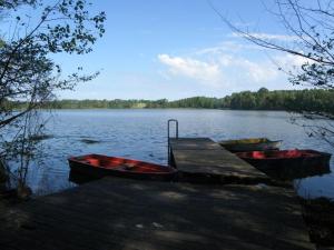 three boats are docked at a dock on a lake at Ferienwohnung Stolz G in Ulrichshusen