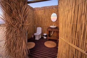 a wooden bathroom with a sink and a toilet at Ocean Camp in Al Qārin +54 photos