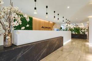 a lobby with aania sign on the wall and flowers at Alua Leo in Can Pastilla
