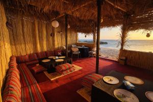 a dining room with a view of the ocean at Ocean Camp in Al Qārin