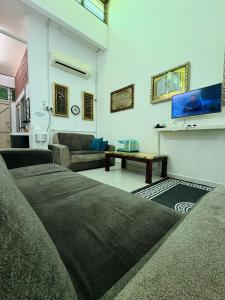 a living room with a couch and a table at Lanang Islamic Homestay in Bedung