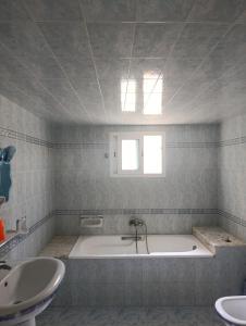 a bathroom with a bath tub and a sink at Cozy house in Nabeul