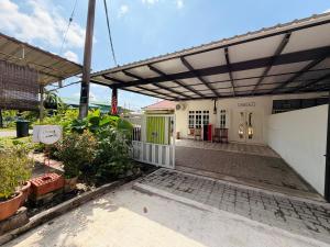 a patio with awning and plants in front of a building at Lanang Islamic Homestay in Bedung