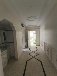 a large white room with a hallway with a tile floor at Cozy house in Nabeul +5 photos