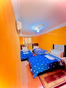 two beds in a room with yellow walls at La paillade in Oulad Barrehil