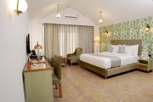 a hotel room with a bed and a desk at Yadus By Alcor in Bīsalpur +47 photos