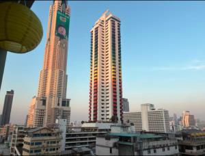 two tall skyscrapers in a city with buildings at Cozy 1br walk to BTS and Airport Rail Link Close to Malls G7 in Bangkok