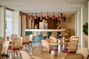 a room with a bar with chairs and tables at Alua Leo in Can Pastilla