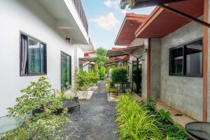 a courtyard of a house with plants and tables at Malinee Resort in Bang Tao Beach