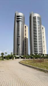 three tall buildings in front of a parking lot at 3 Bedroom Luxury Apartment in Eko Atlantic City in Lagos