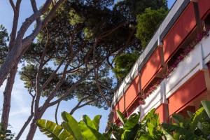 a building with trees in the background at La Serena Forte dei Marmi, Small Luxury Hotels of the World in Forte dei Marmi +60 photos