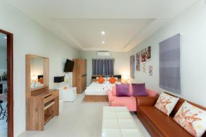 a living room with a couch and a bed at Malinee Resort in Bang Tao Beach