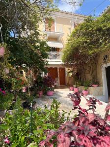 ein Garten mit Topfpflanzen vor einem Haus in der Unterkunft Καμέλια 3 in Fiskardo