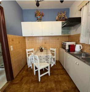 eine Küche mit Tisch und Stühlen in einer Küche in der Unterkunft Καμέλια 3 in Fiskardo