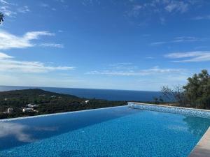 a swimming pool with a view of the ocean at Carob Breeze House in Krimovice