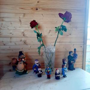 a group of figurines standing around a vase with a flower at Guesthouse IMEDI in Velistsʼikhe