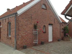 a red brick building with a white door at Klaassen- Ferienhaus Up Warf in Emden