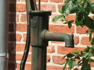 a green metal door handle on a brick wall at Klaassen- Ferienhaus Up Warf in Emden