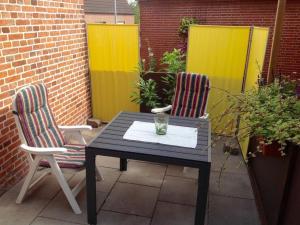two chairs and a table on a patio at Klaassen- Ferienhaus Up Warf in Emden