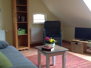 a living room with a couch and a table with flowers on it at Klaassen- Ferienhaus Up Warf in Emden +29 photos