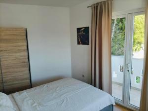 a bedroom with a bed and a large window at Apartments Malou in Baška Voda +20 photos