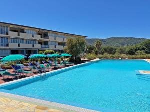 a hotel with a swimming pool with chairs and umbrellas at Residenza Verde Blu - ArgonautiVacanze in Capoliveri