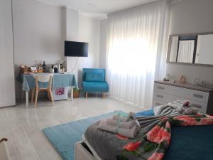 a bedroom with a bed and a table and a blue chair at Shine Flowers Room in Scordia