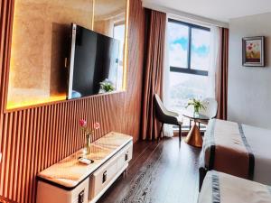 a hotel room with a bed and a tv at Pristine Coast Residences in Phan Thiet +3 photos