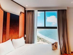 a bedroom with a bed and a view of the ocean at Pristine Coast Residences in Phan Thiet